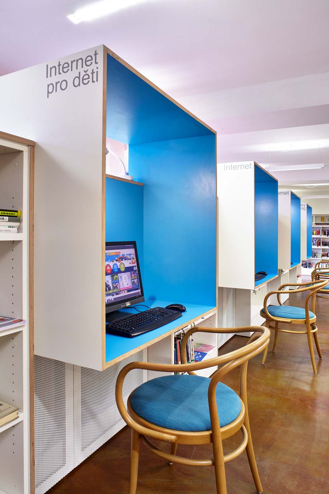 Naproti stolům knihovníkům jsou modré internetové boxy, které zároveň tvoří záda velké pohovce. foto: Andrea Thiel Lhotáková