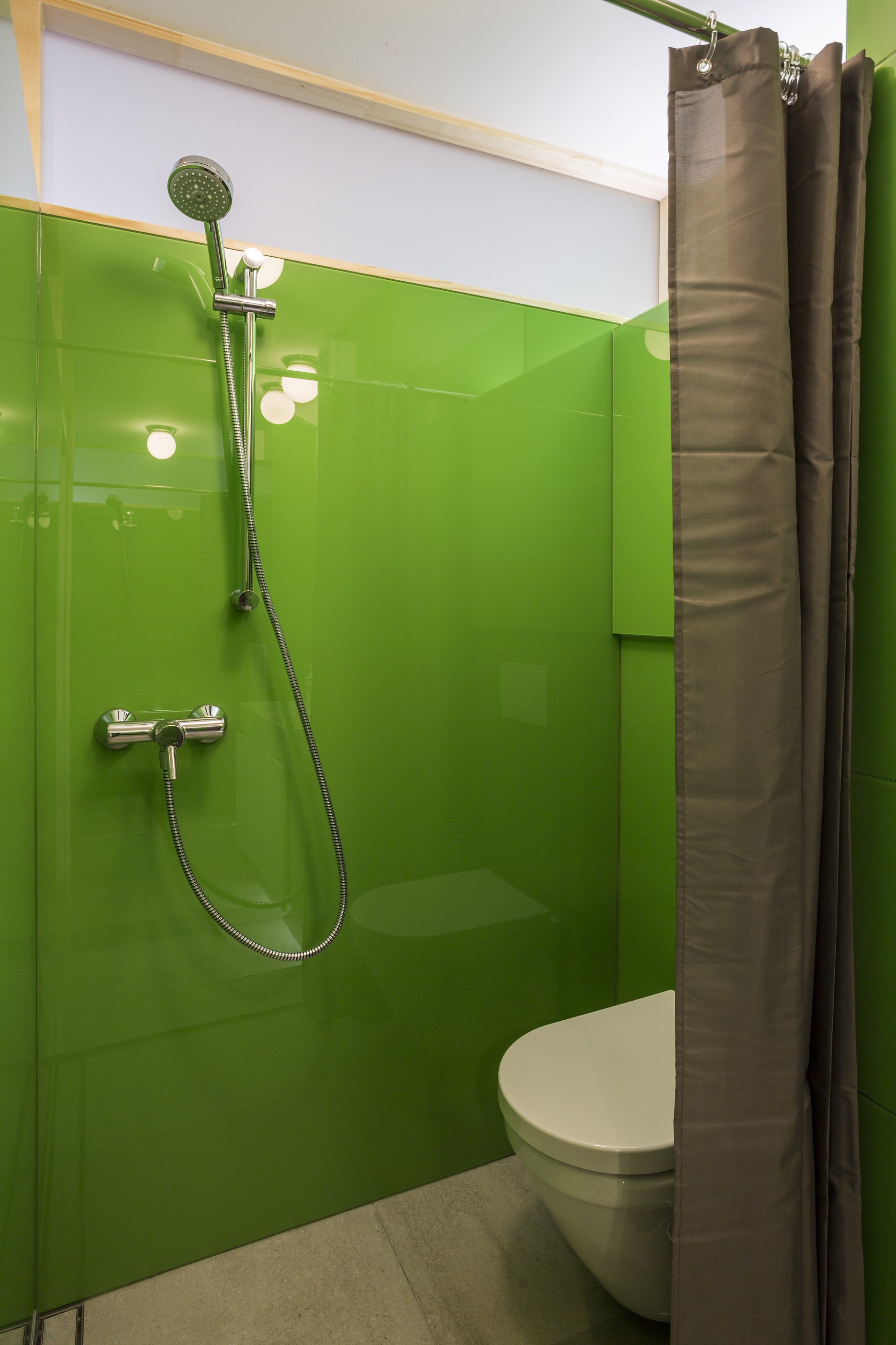Kvôli rozmerom hygieny musel byť aj sprchový kút riešený neštandardne. Na obklad stien bol použitý zelený Lacobel, ktorý zabezpečuje ľahkú údržbu.