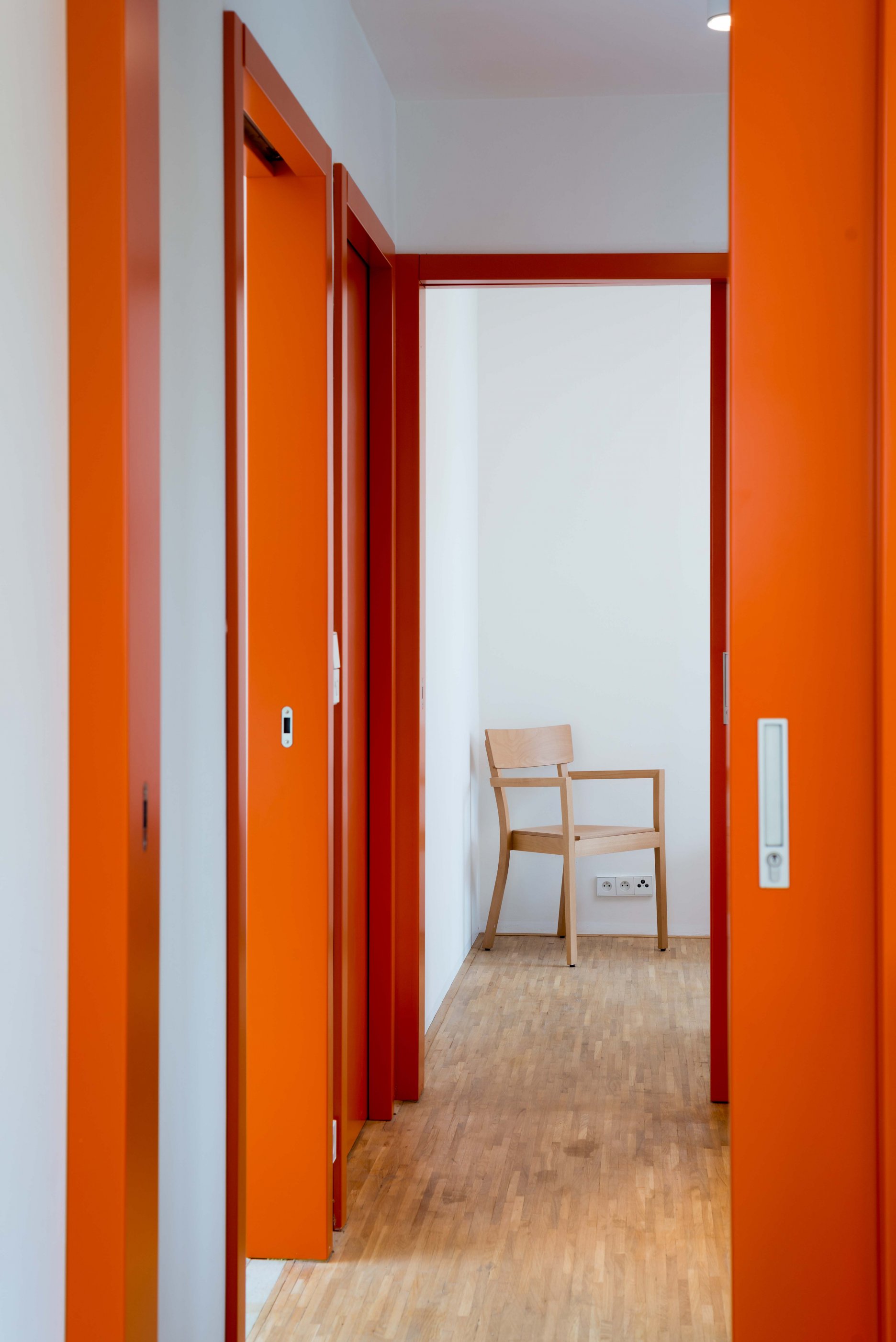 Oranžové akcenty zárubní a okenných rámov prechádzajú aj do interiéru. 