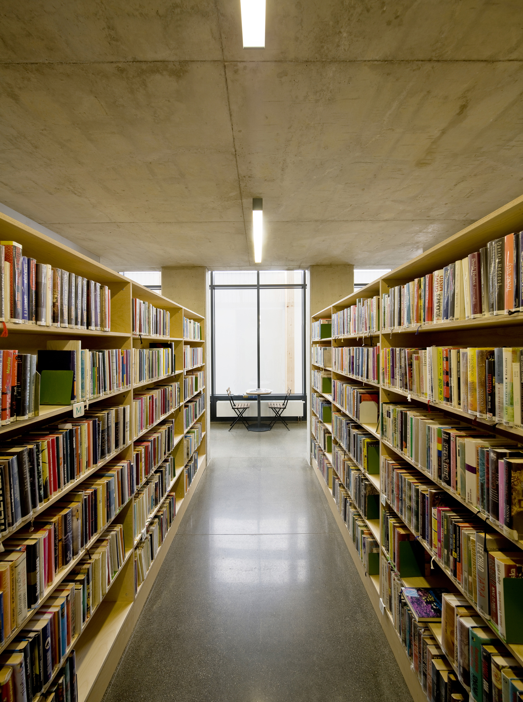 Drevené police s knihami pod stropom čitárne.